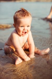 The small child sits in the water