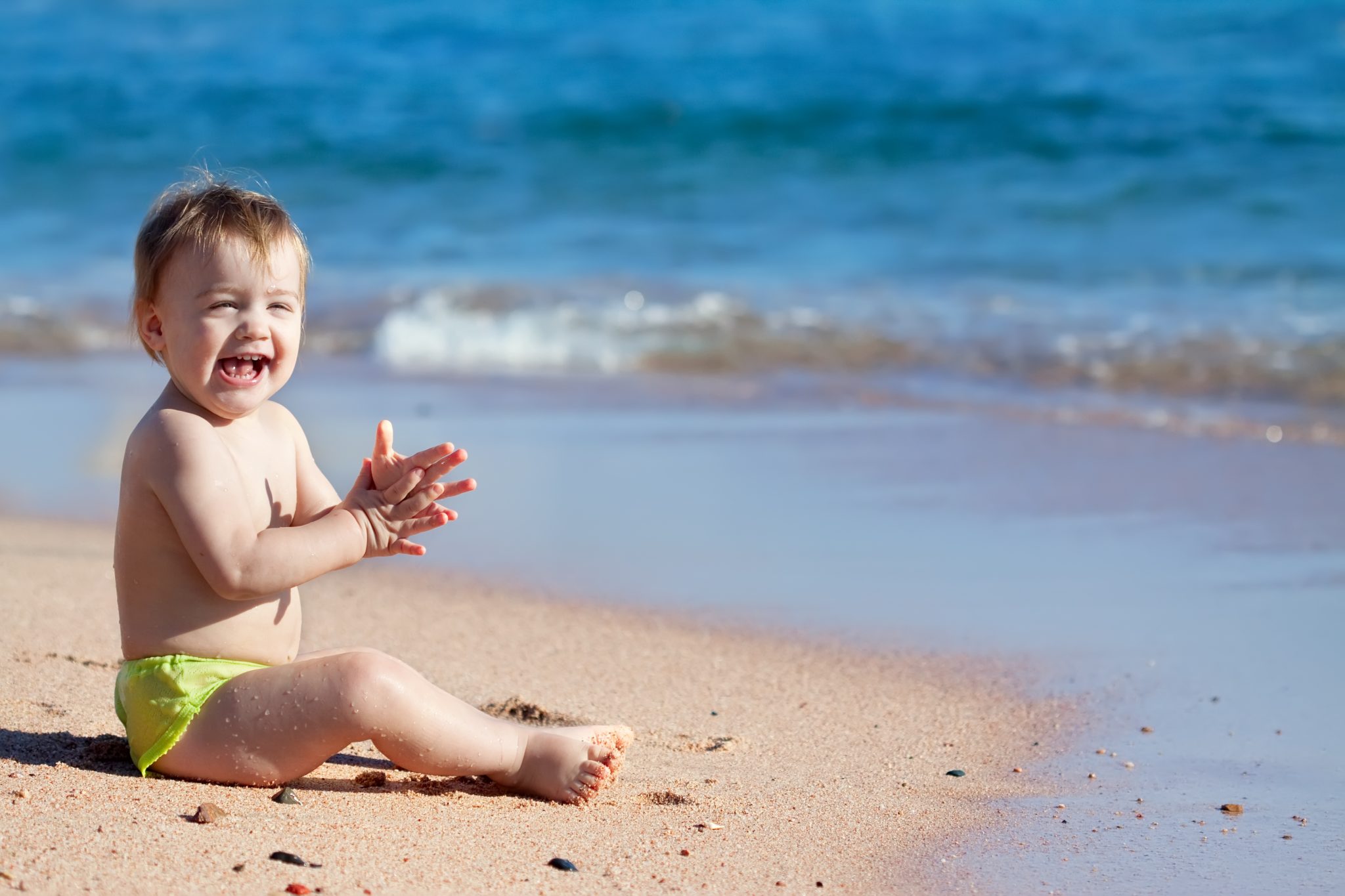 The small child sits in the water